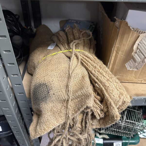 Bundle of vintage hessian sacks for storage and display.