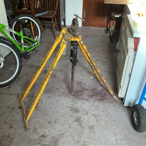 Yellow Hilmor pipe bending stand in a workshop setting.