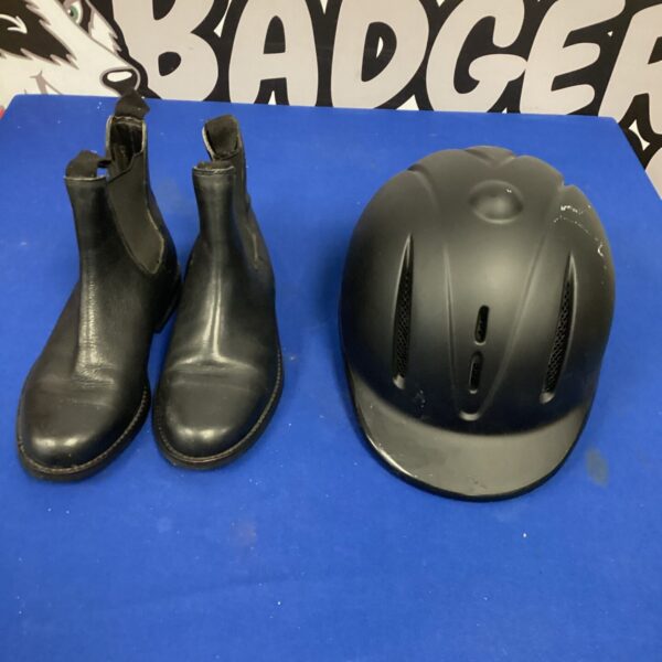 Black horse riding boots and helmet set for equestrian sports.