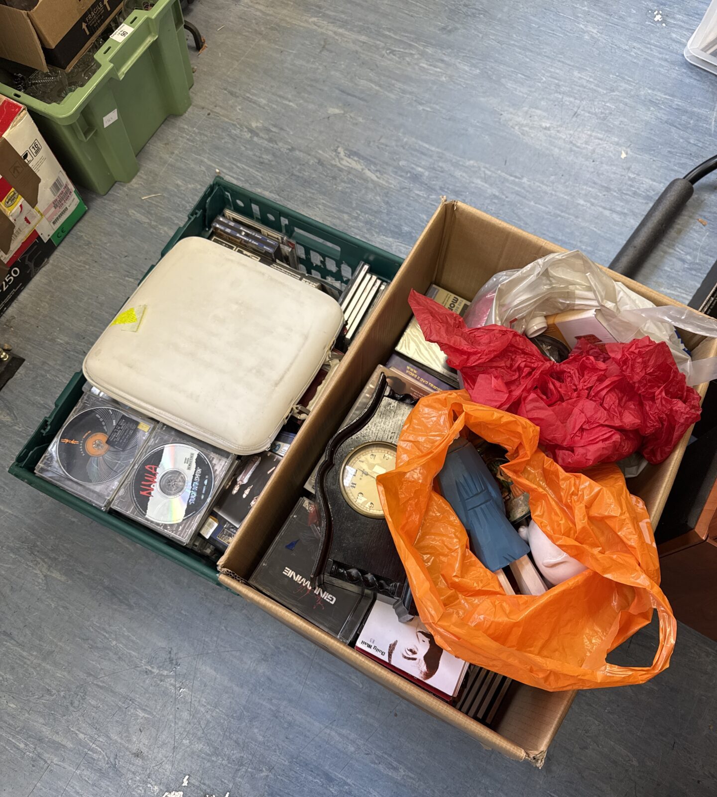 Mixed house clearance lot with boxes of CDs and ornaments.