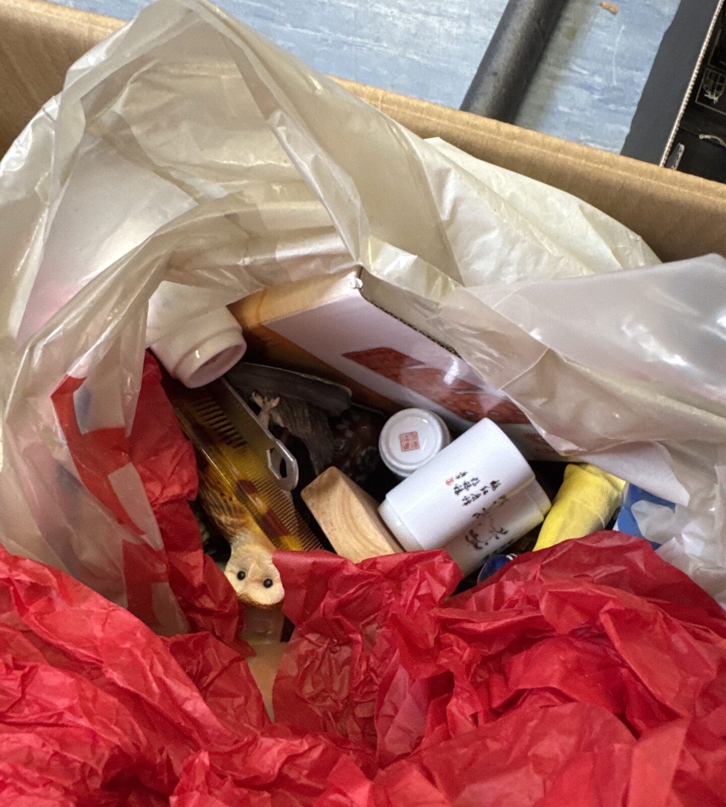 Close-up of house clearance lot items in a box.
