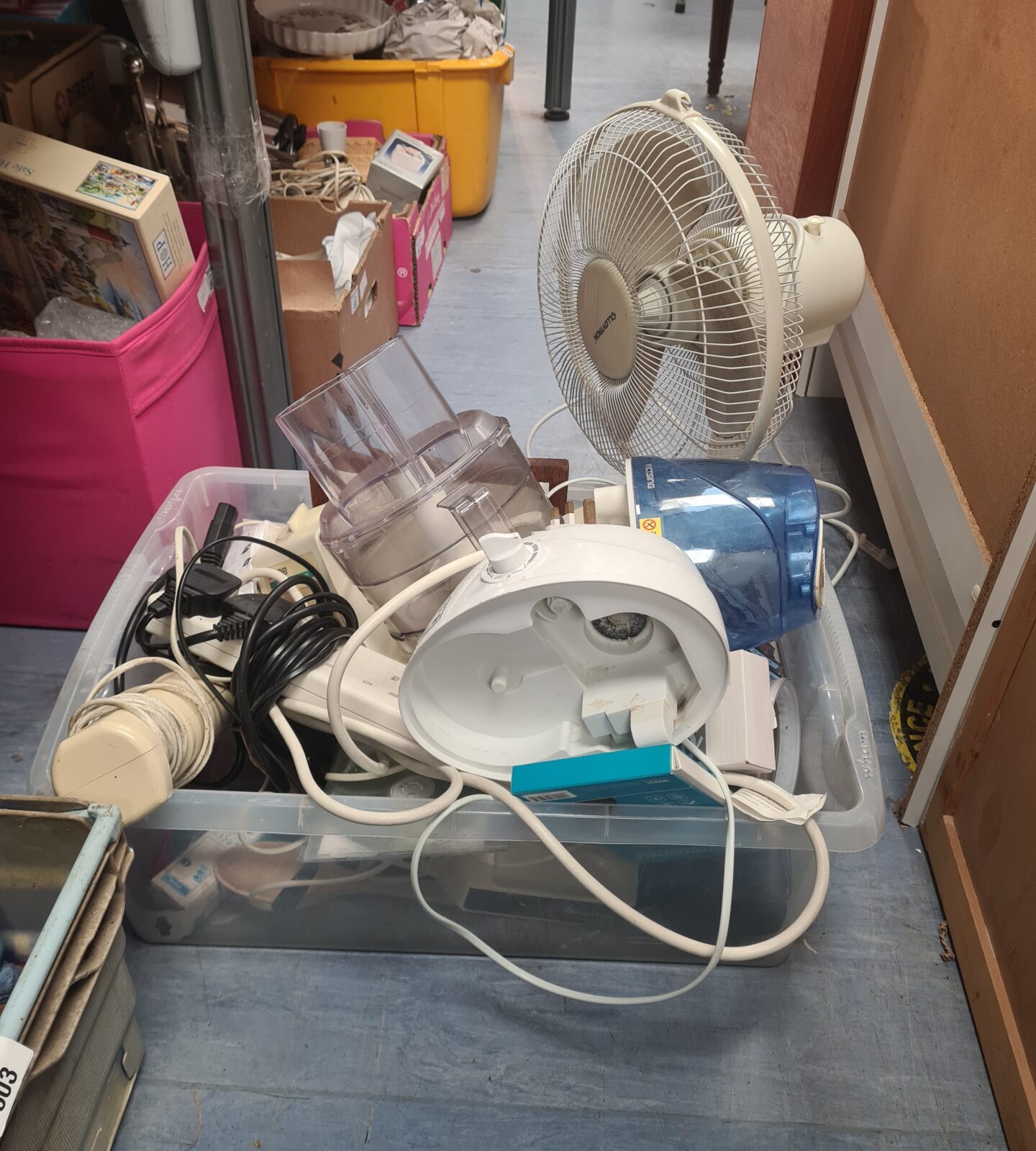 House clearance lot with kitchenware and a portable fan.