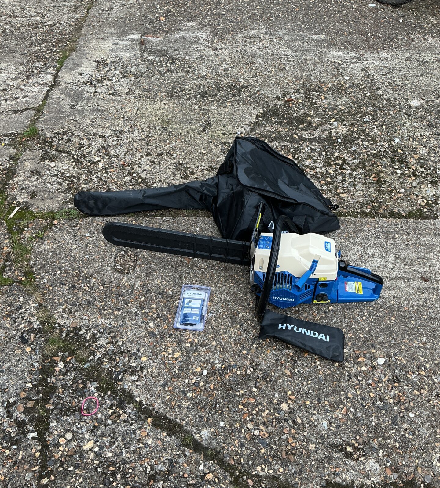Hyundai petrol chainsaw with case and tools for garden maintenance.