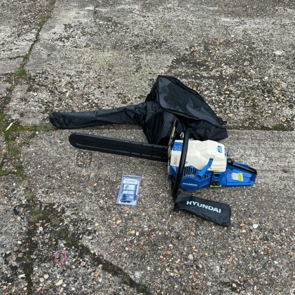 Hyundai petrol chainsaw with case and tools for garden maintenance.
