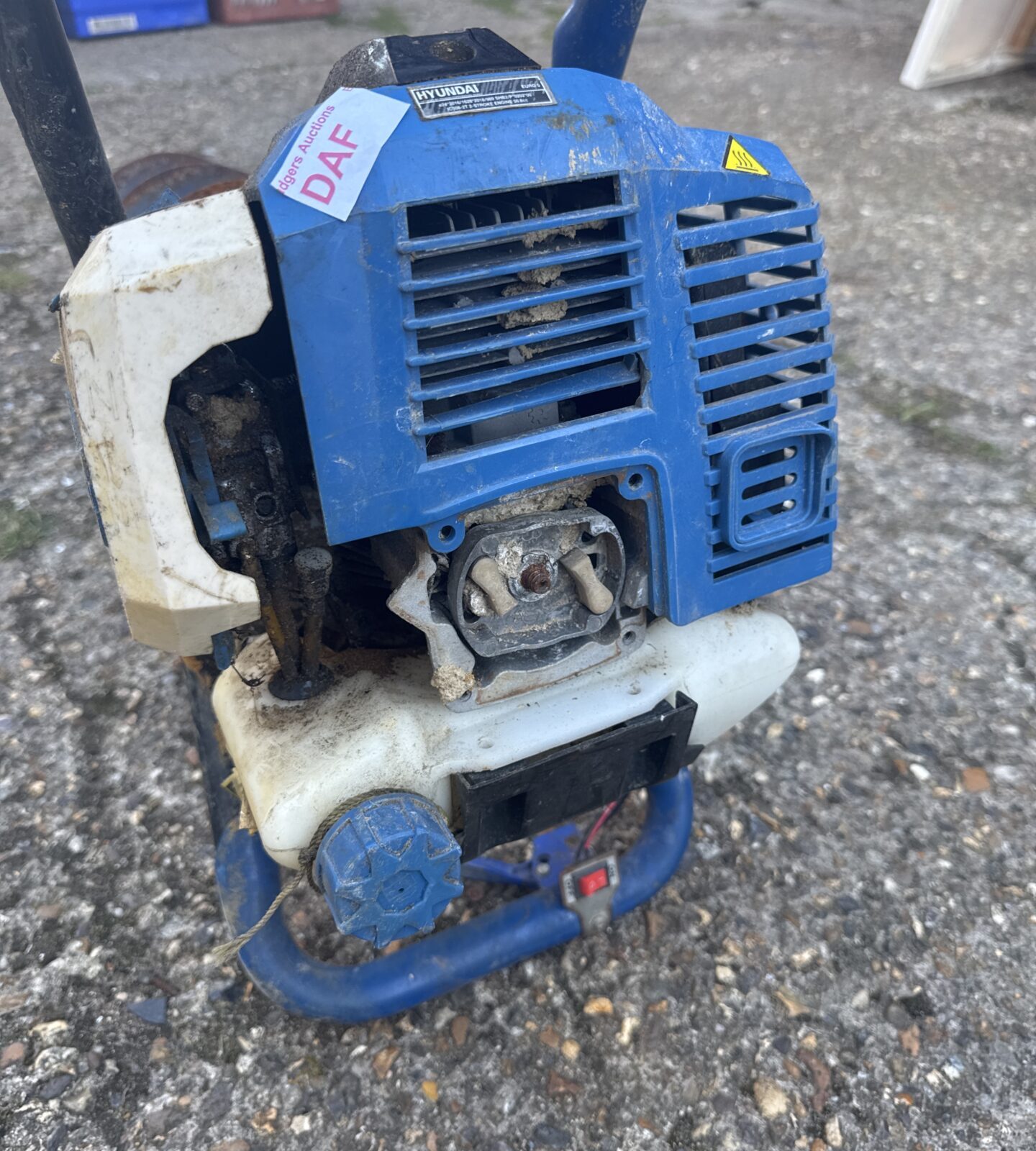 Side view of Hyundai post hole borer engine and controls.
