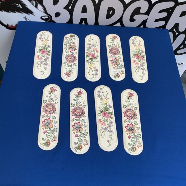 Antique porcelain door finger plates with delicate floral designs, Victorian era.
