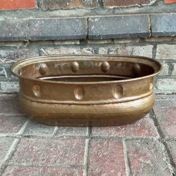 Vintage copper trough planter for garden display.
