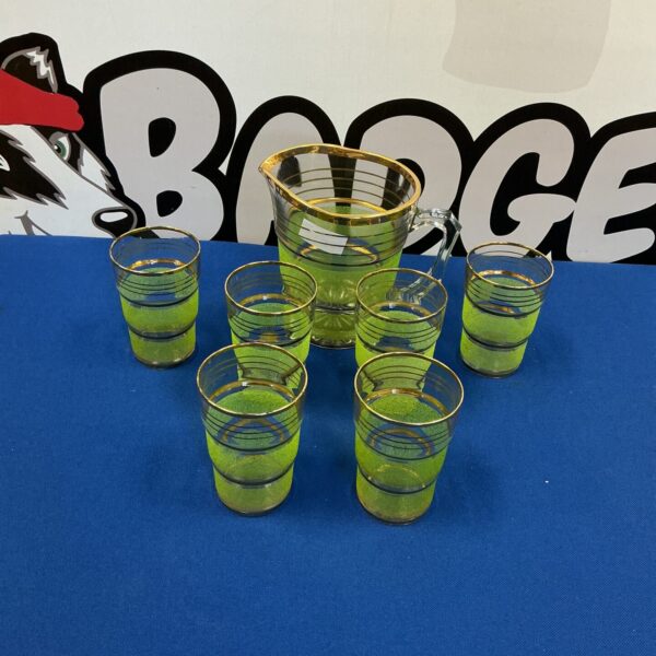 Vintage green glass tumblers and pitcher set, mid-century modern style.