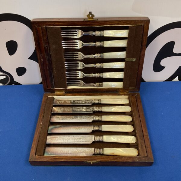 Vintage silver plate cutlery set with mother of pearl handles in wooden box.