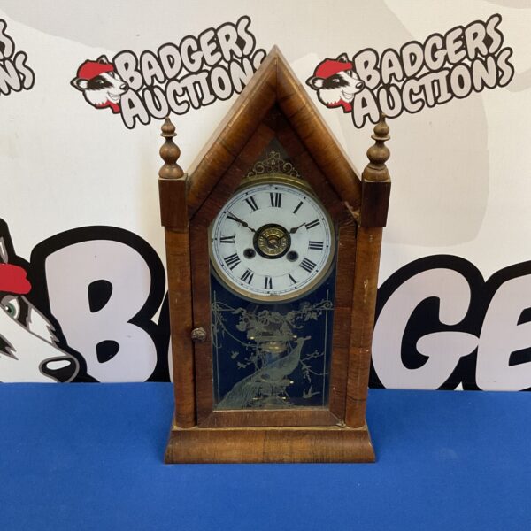 Antique American spire clock with peacock design, front view.