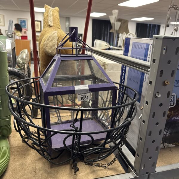 Two wire framed hanging baskets with a hanging lantern