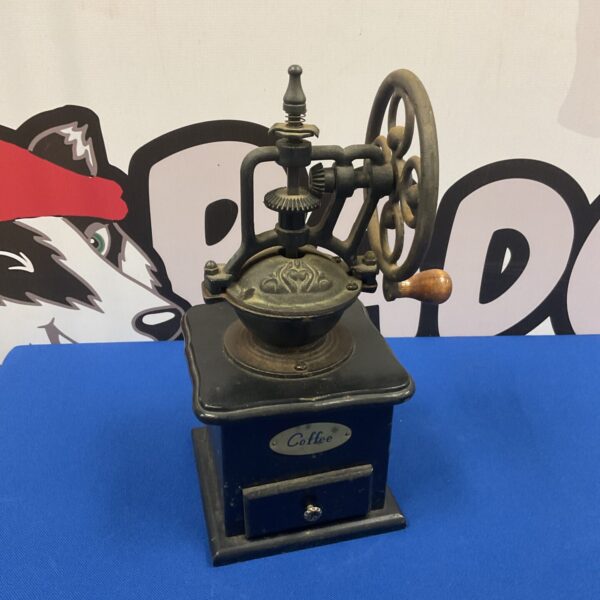 Front view of a vintage hand-cranked coffee mill.