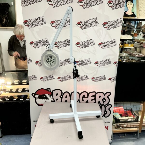 Floor-standing clinic magnification light with adjustable arm.