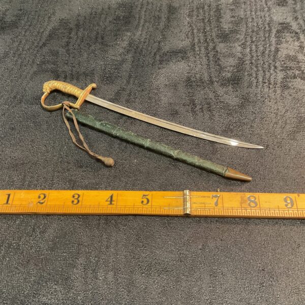 Antique German military paper knife with sword knot on display.
