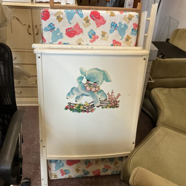 Vintage baby cot with patterned fabric panels, antique nursery furniture.
