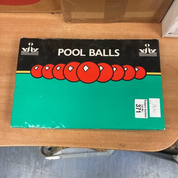 Vintage pool balls set in green box, collectible billiards equipment.