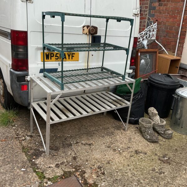 Two vintage metal greenhouse tables for garden staging.