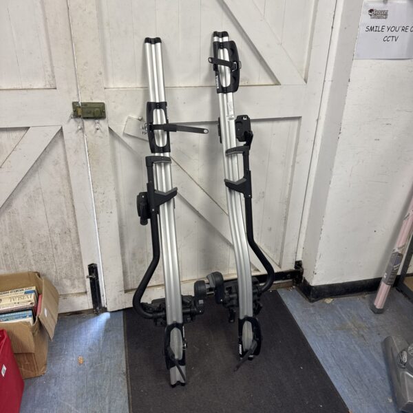 Pair of Thule roof cycle racks with keys for secure bike transport.