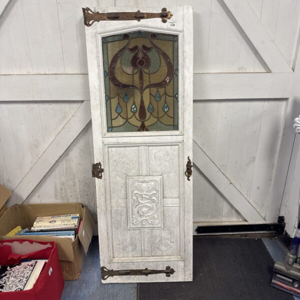 Antique stained glass pantry door with floral design.