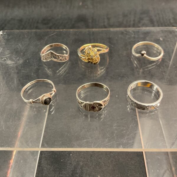 Mixed lot of six 925 silver rings on a white surface.