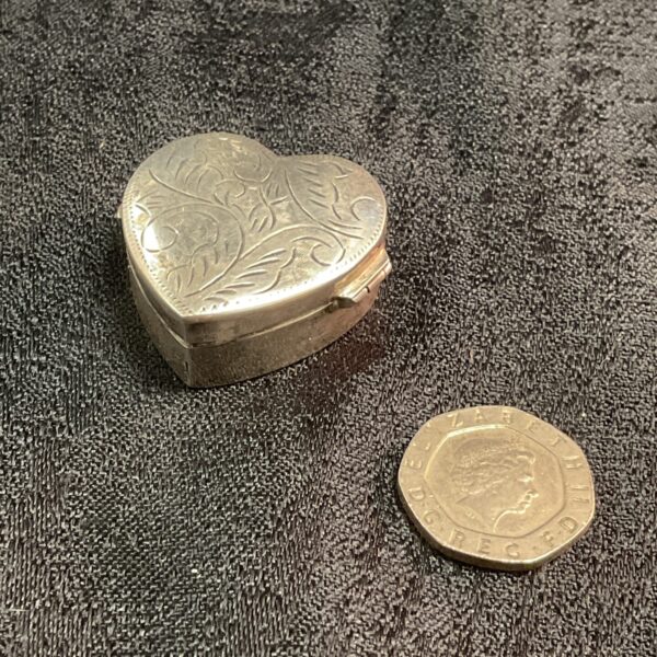 Antique silver heart pill box with floral detailing.