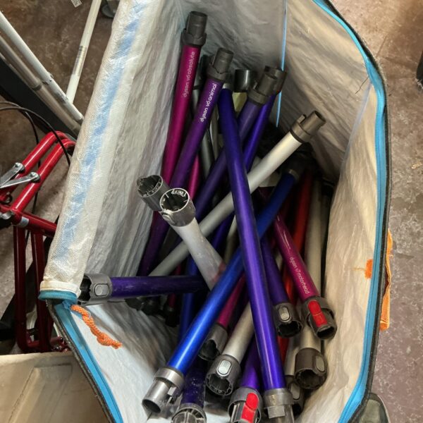 Assorted Dyson vacuum cleaner parts and spares in a blue bag.