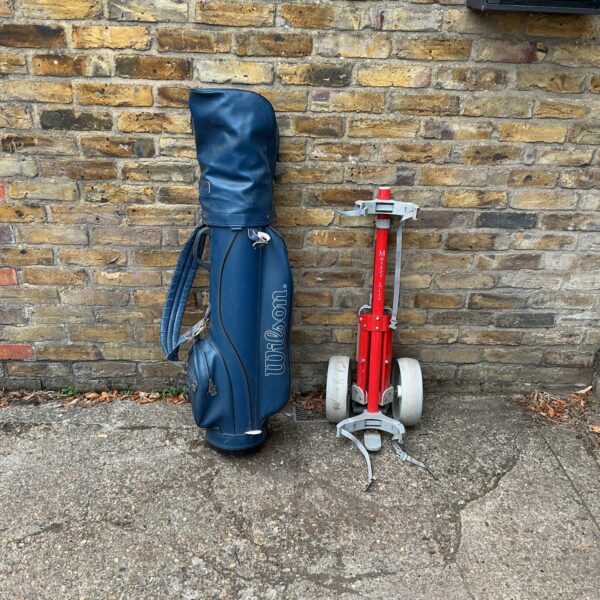 Vintage Wilson golf clubs and cart in blue, retro sporting goods.