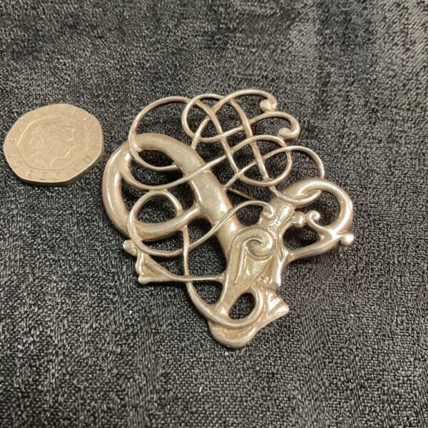 Antique silver Art Nouveau brooch with delicate floral design.