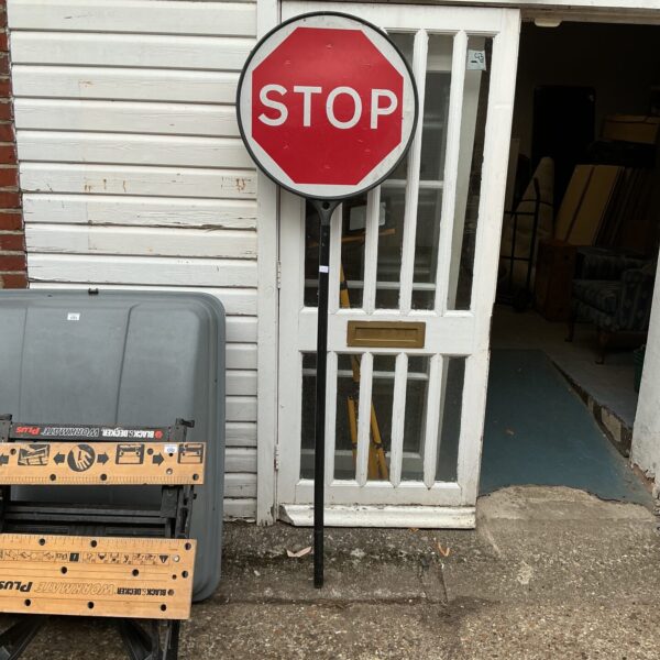 Vintage stop sign in a garden setting, weathered metal.