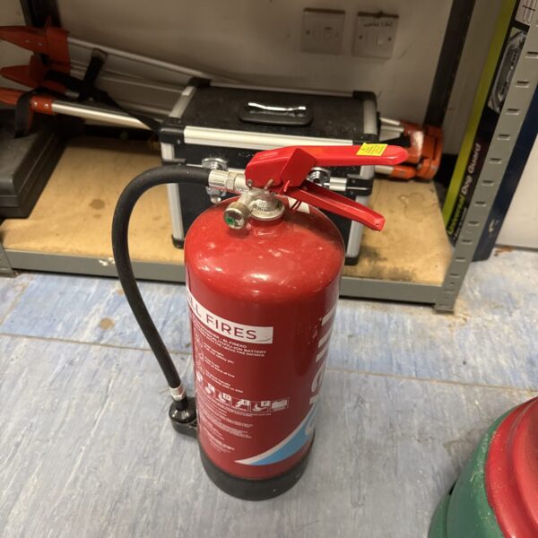 Red Firexo fire extinguisher in a workshop setting.