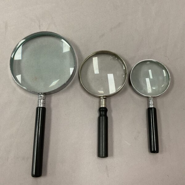 Vintage set of three magnifying glasses with wooden handles.