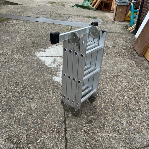 Silver GS multi function ladder leaning against a wall.