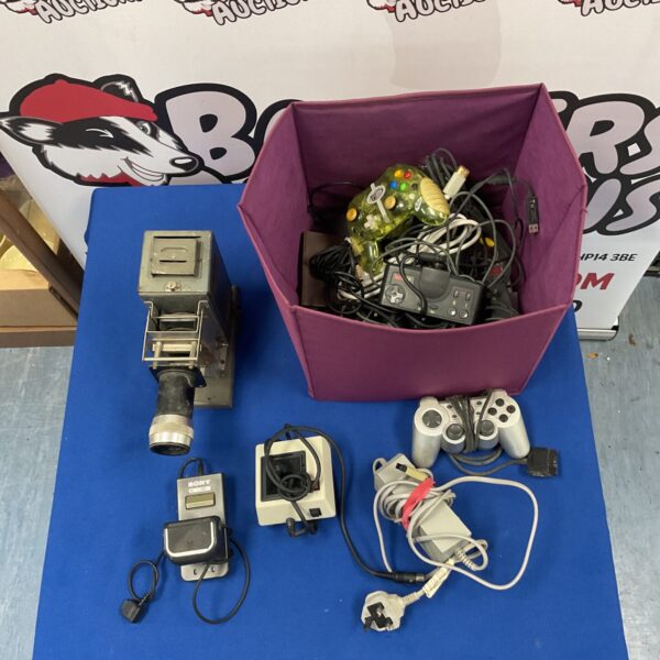 Vintage gaming lot with slide projector and retro gamepads.