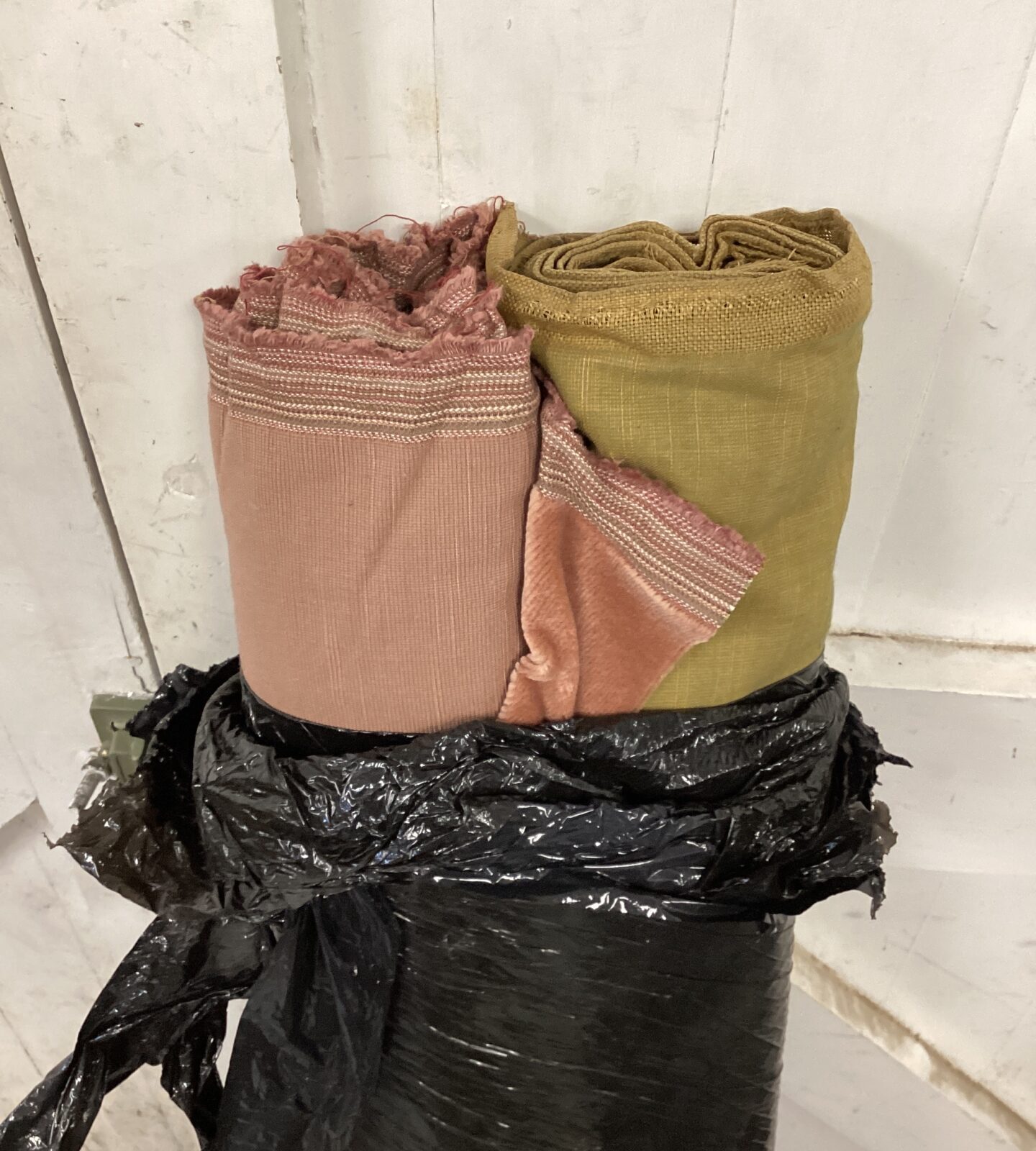 Two rolls of fabric one green & one pink