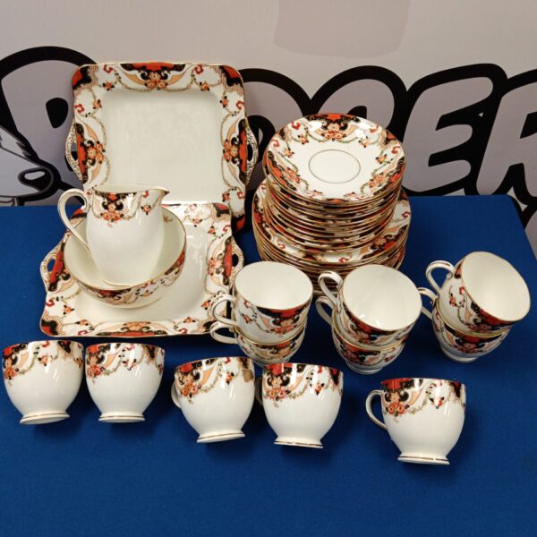 Full view of a vintage Imari china set with plates, cups, and saucers.