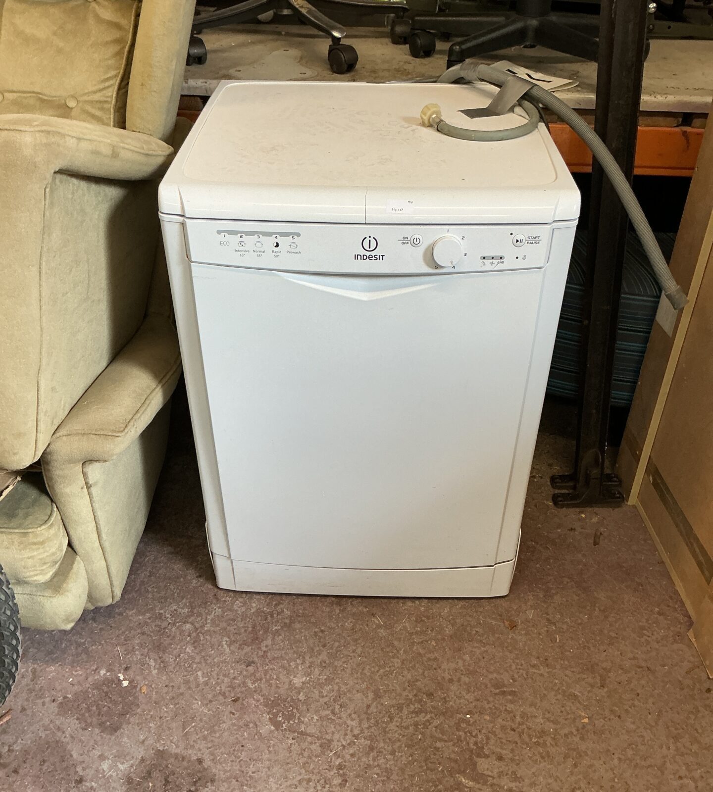 White Indesit dishwasher in a home kitchen setting.