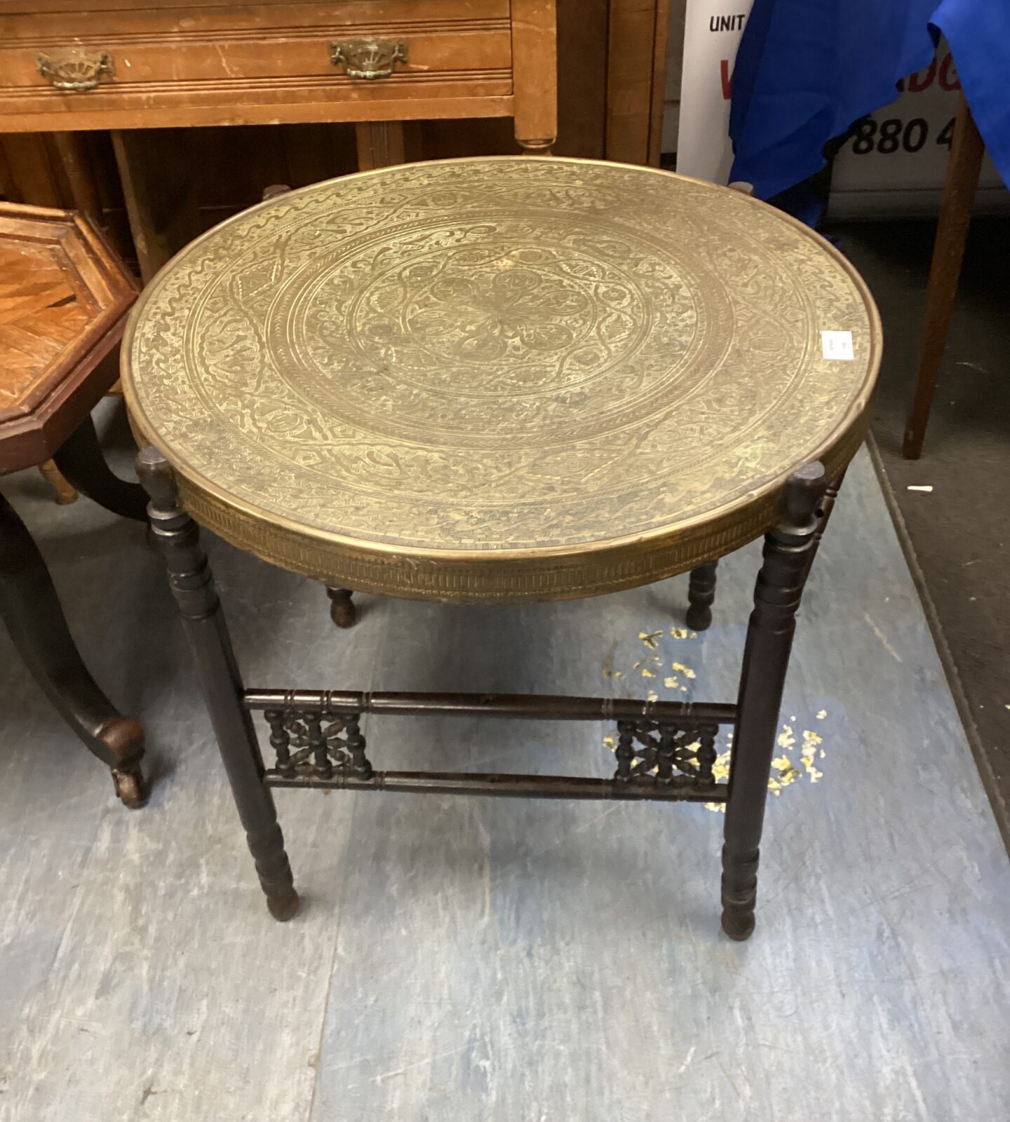 Vintage Indian brass table with embossed top and tripod base.