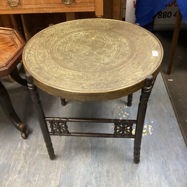 Vintage Indian brass table with embossed top and tripod base.