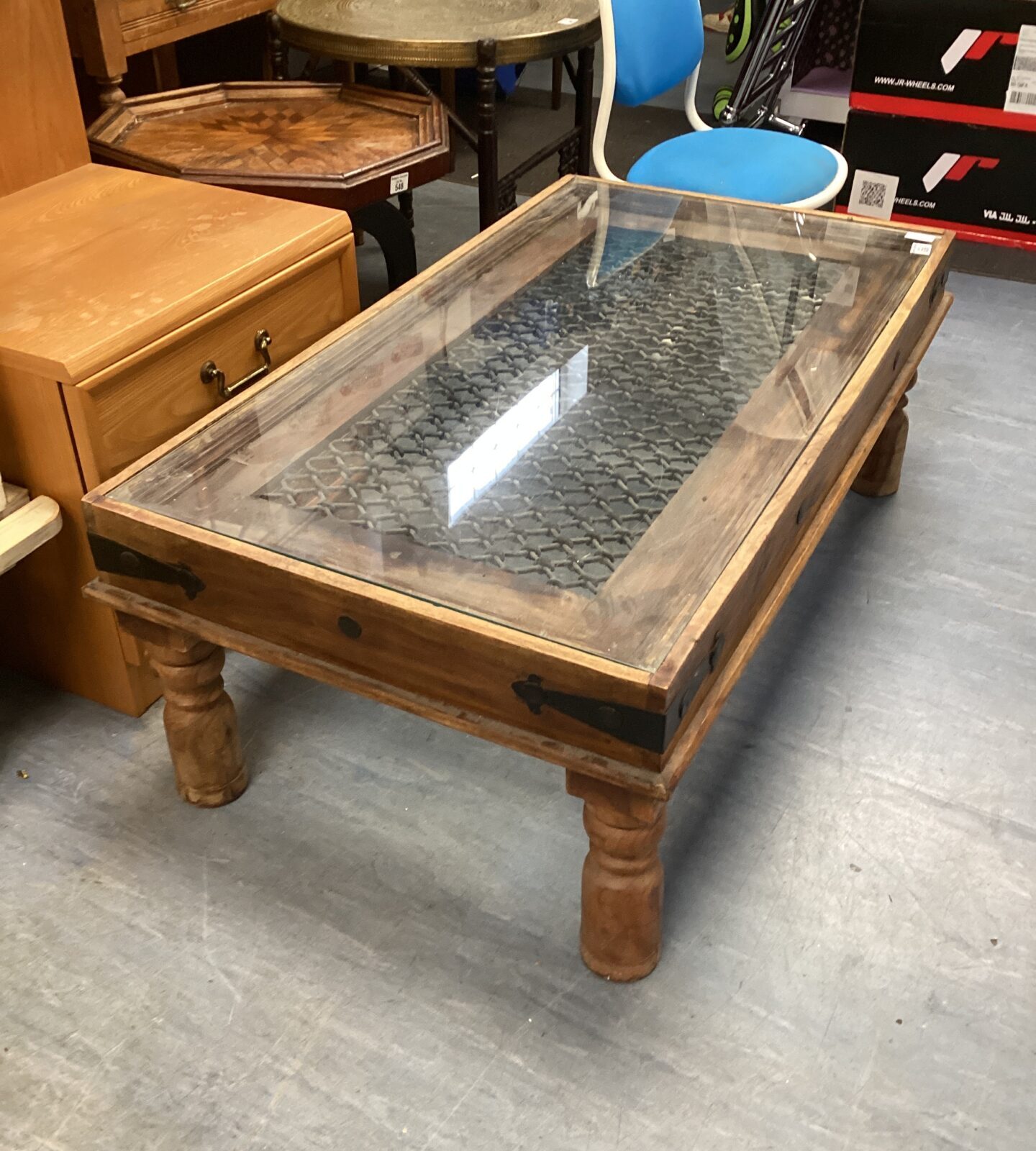 Intricate Indian coffee table with a glass top and inlaid wood detail.