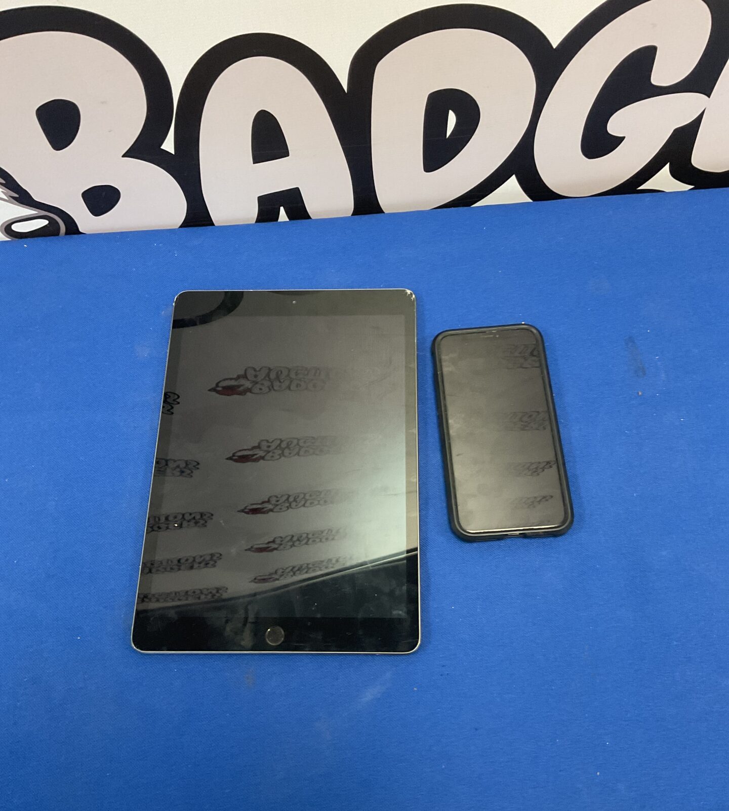 Black iPhone X with a clear case on a blue background.