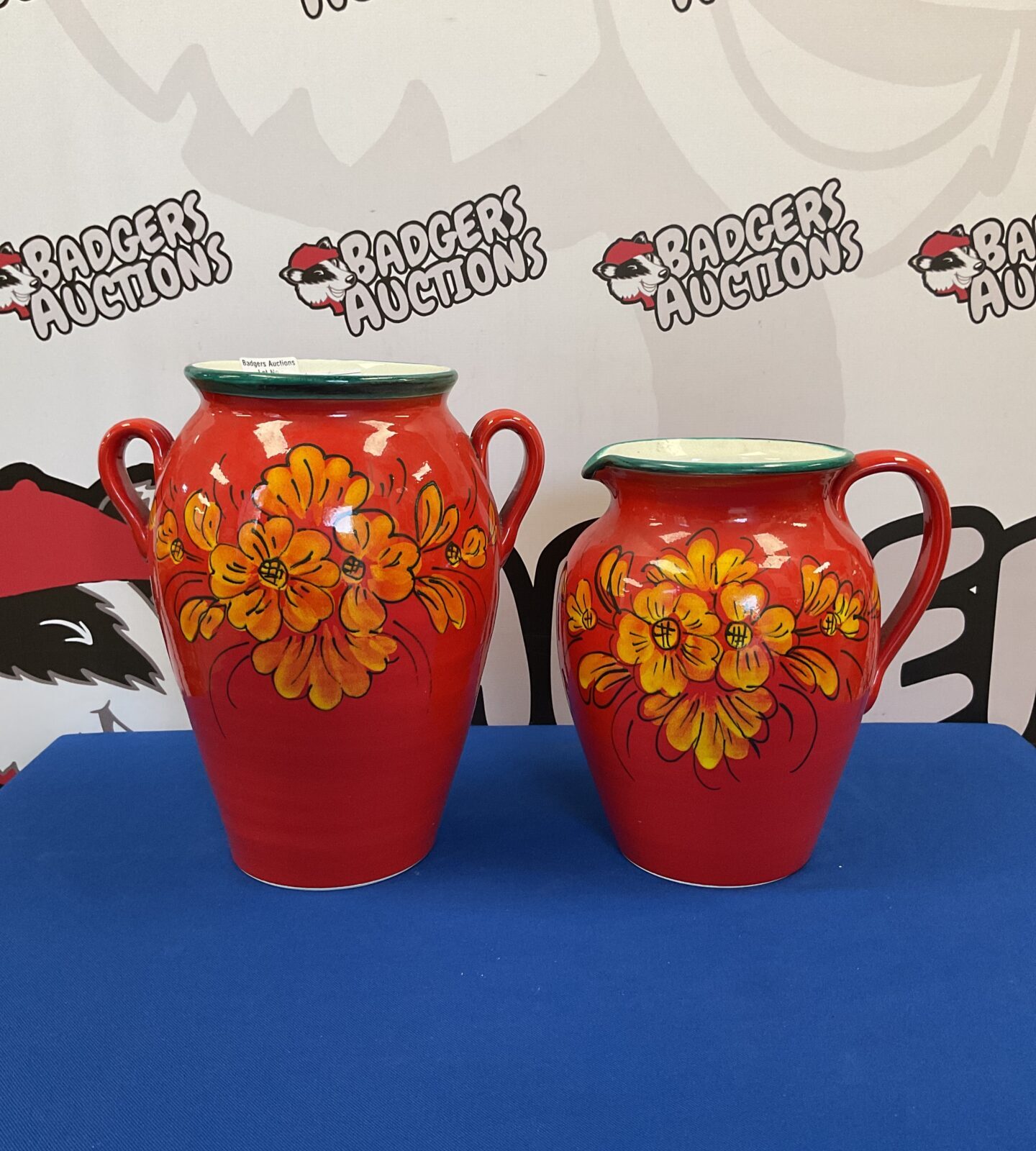 Vibrant red Italian floral jug and vase set for display.