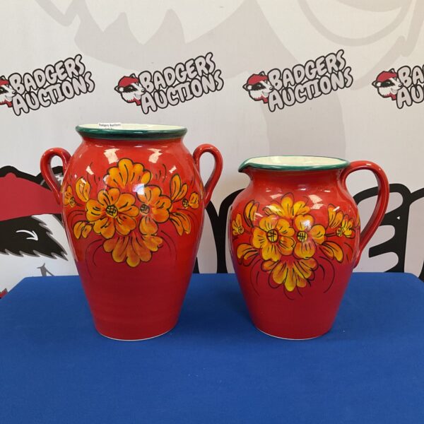 Vibrant red Italian floral jug and vase set for display.