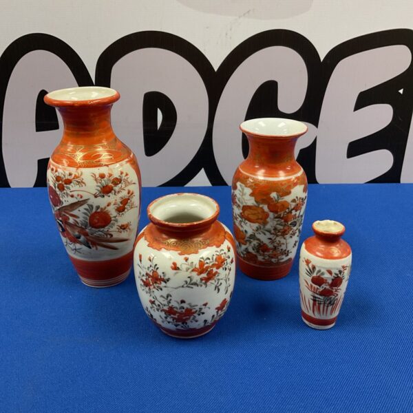 Group of four vintage Japanese kutani miniature vases on blue background.