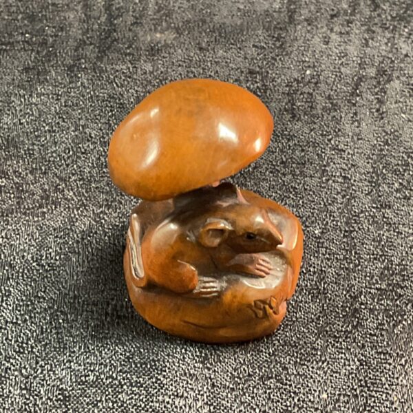 Vintage Japanese netsuke carving of a mouse on a mushroom.