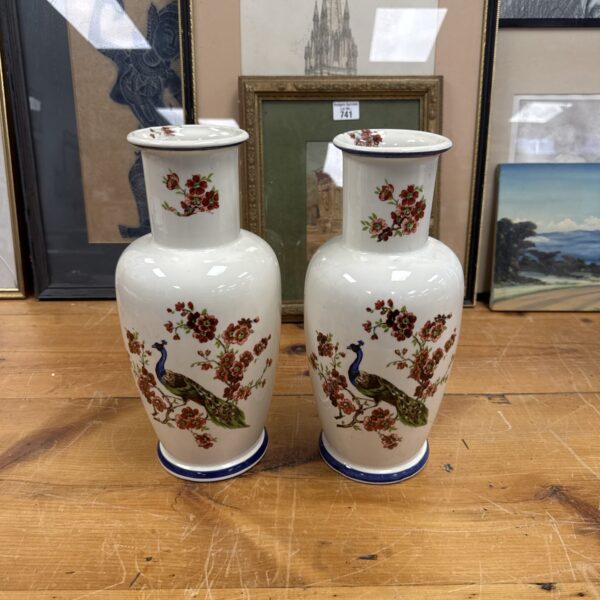 Pair of vintage Japanese peacock vases on a wooden surface.