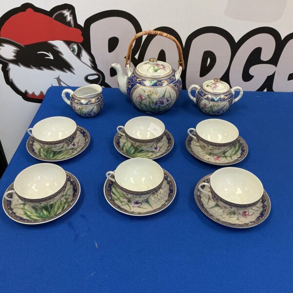 Vintage Japanese porcelain tea set with floral designs.