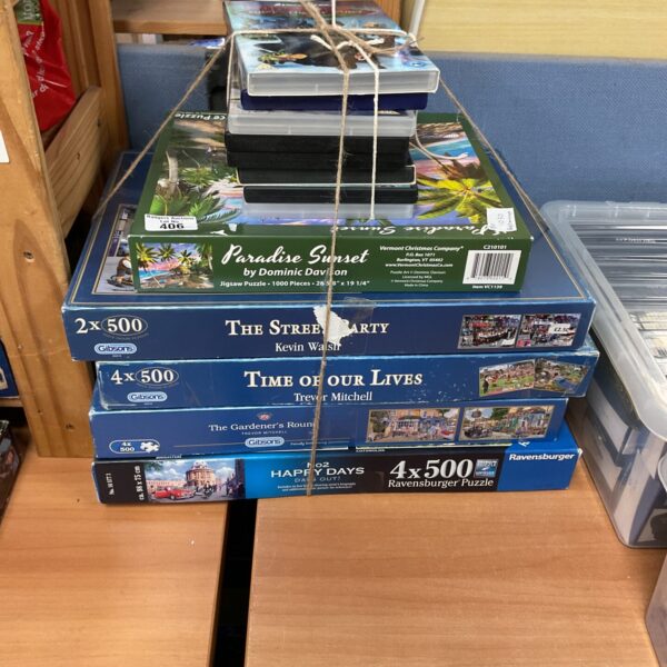 Mixed lot of jigsaw puzzles and DVDs for family entertainment.