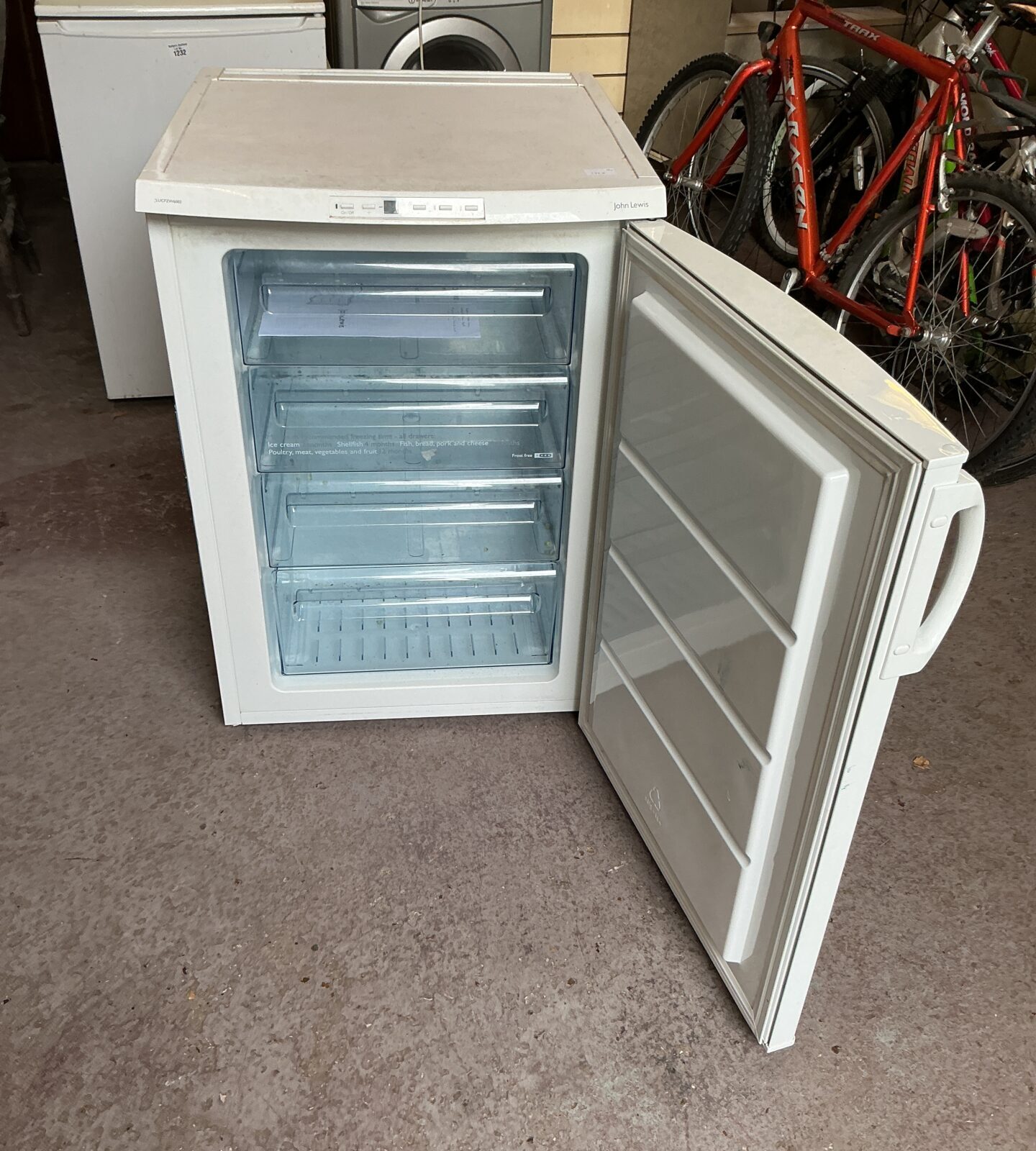 White John Lewis chest freezer open, showing interior storage baskets.