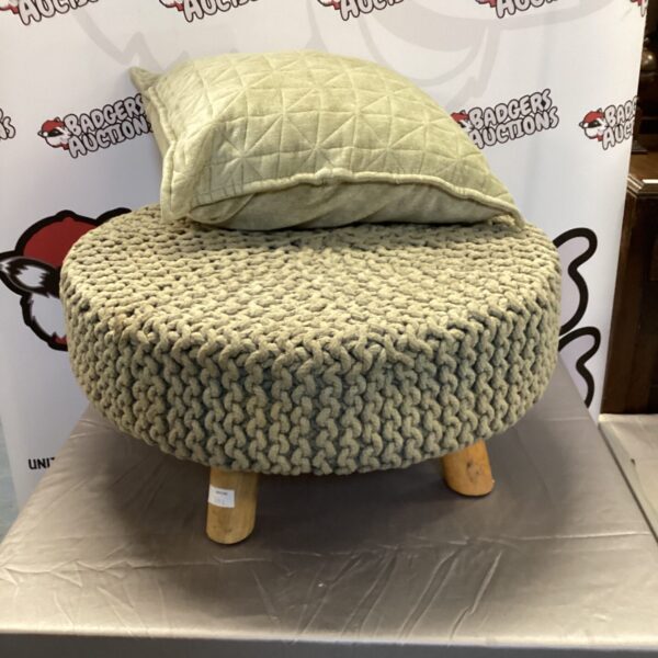 Close-up of a knitted footstool with a textured cover.