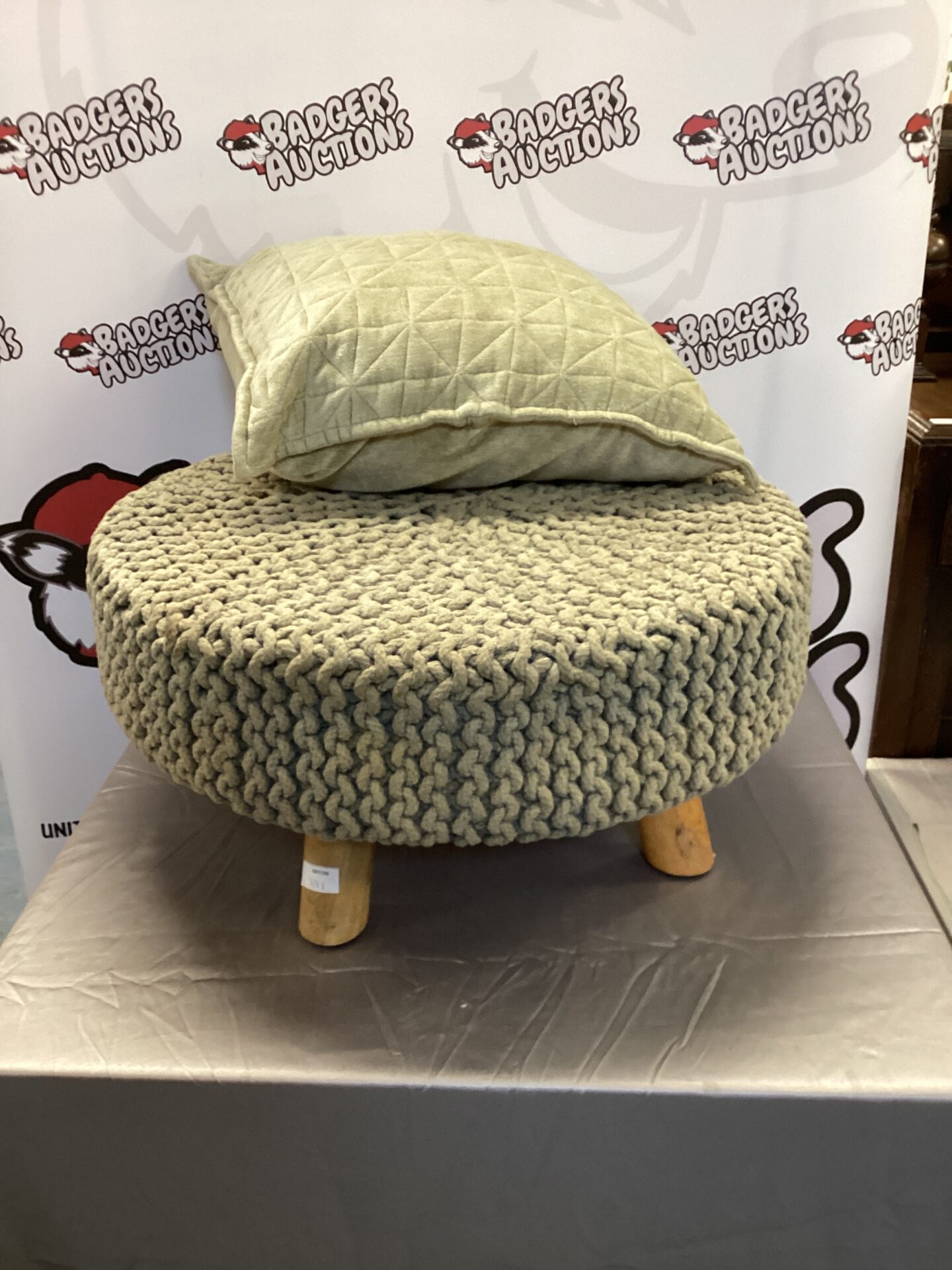 Close-up of a knitted footstool with a textured cover.
